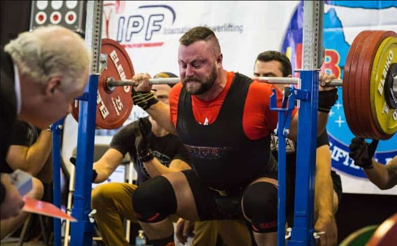 hombre haciendo sentadilla de powerlifting