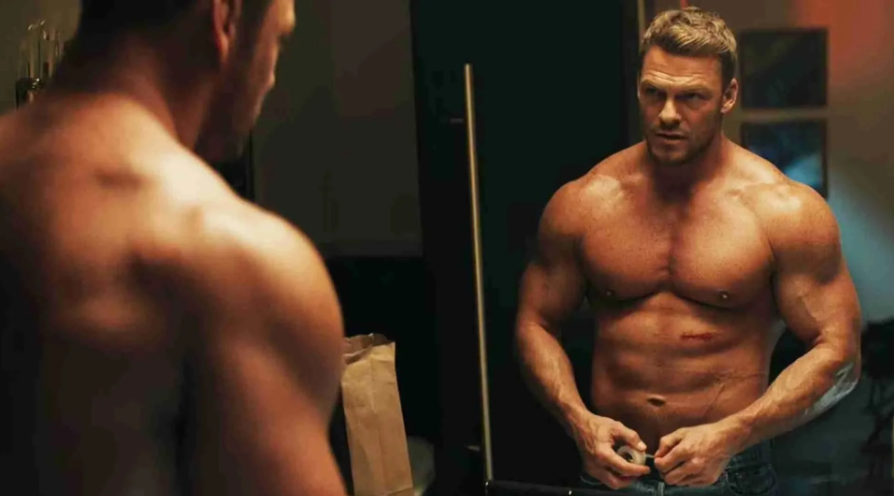 Físico inspirado en Alan Ritchson como Jack Reacher entrenando en un gimnasio